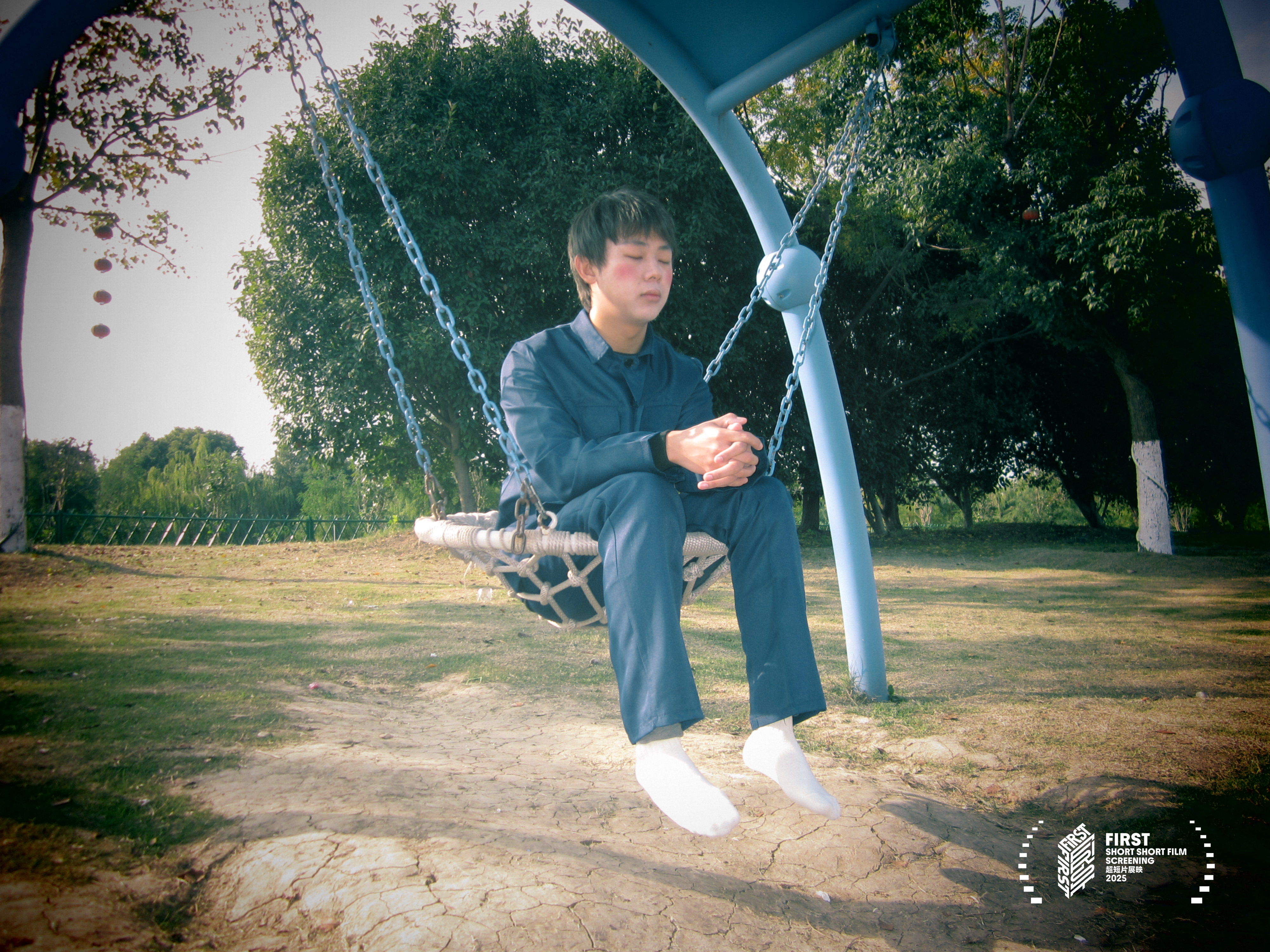 A child sitting on a swing, eyes closed, in Mom Tulip.